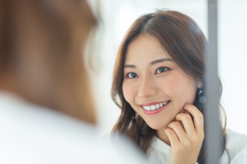 前歯が綺麗になり鏡を見て喜ぶ女性